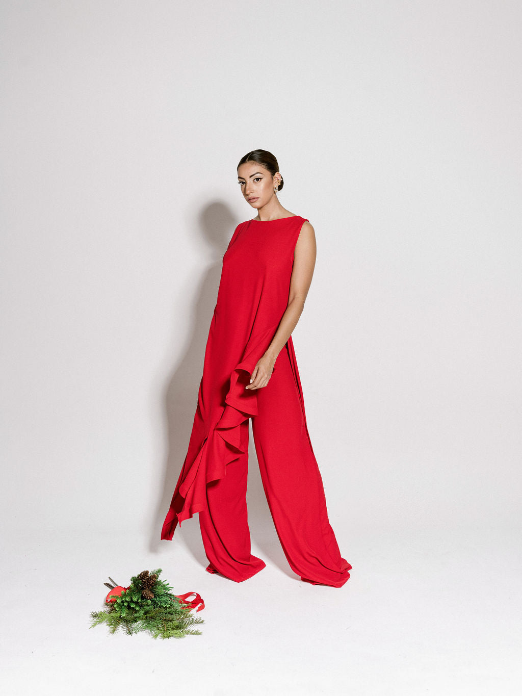 A model wearing a red flowy top with ruffles by Monica Arguedas.
