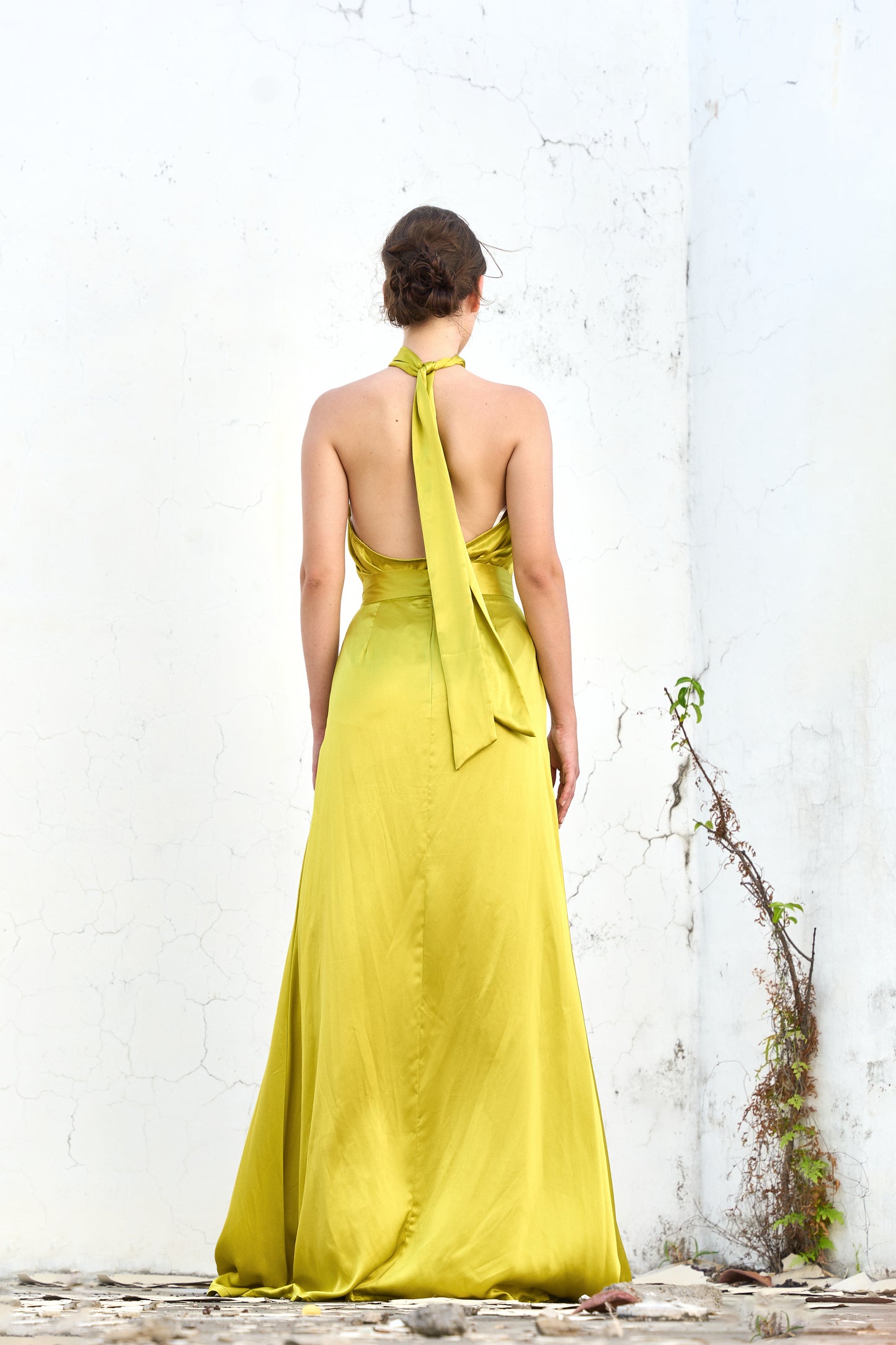 A model wearing a yellow silk skirt with a slit by Monica Arguedas.