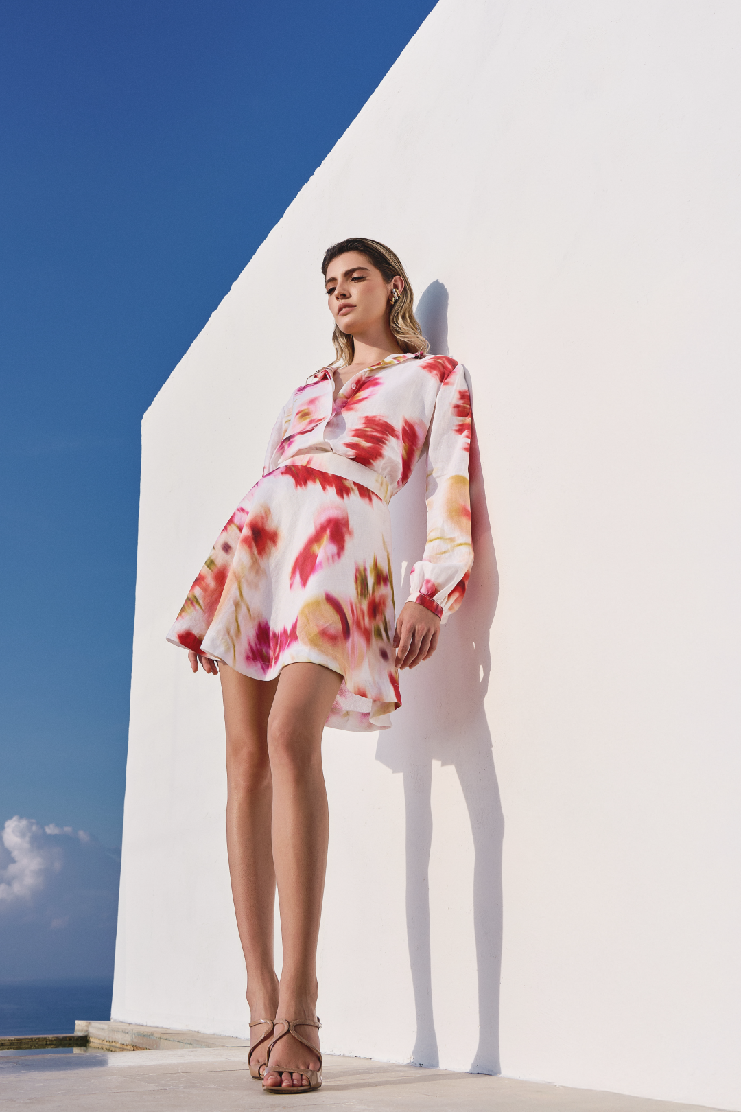 A model wearing a mini skirt with pink floral print by Monica Arguedas.
