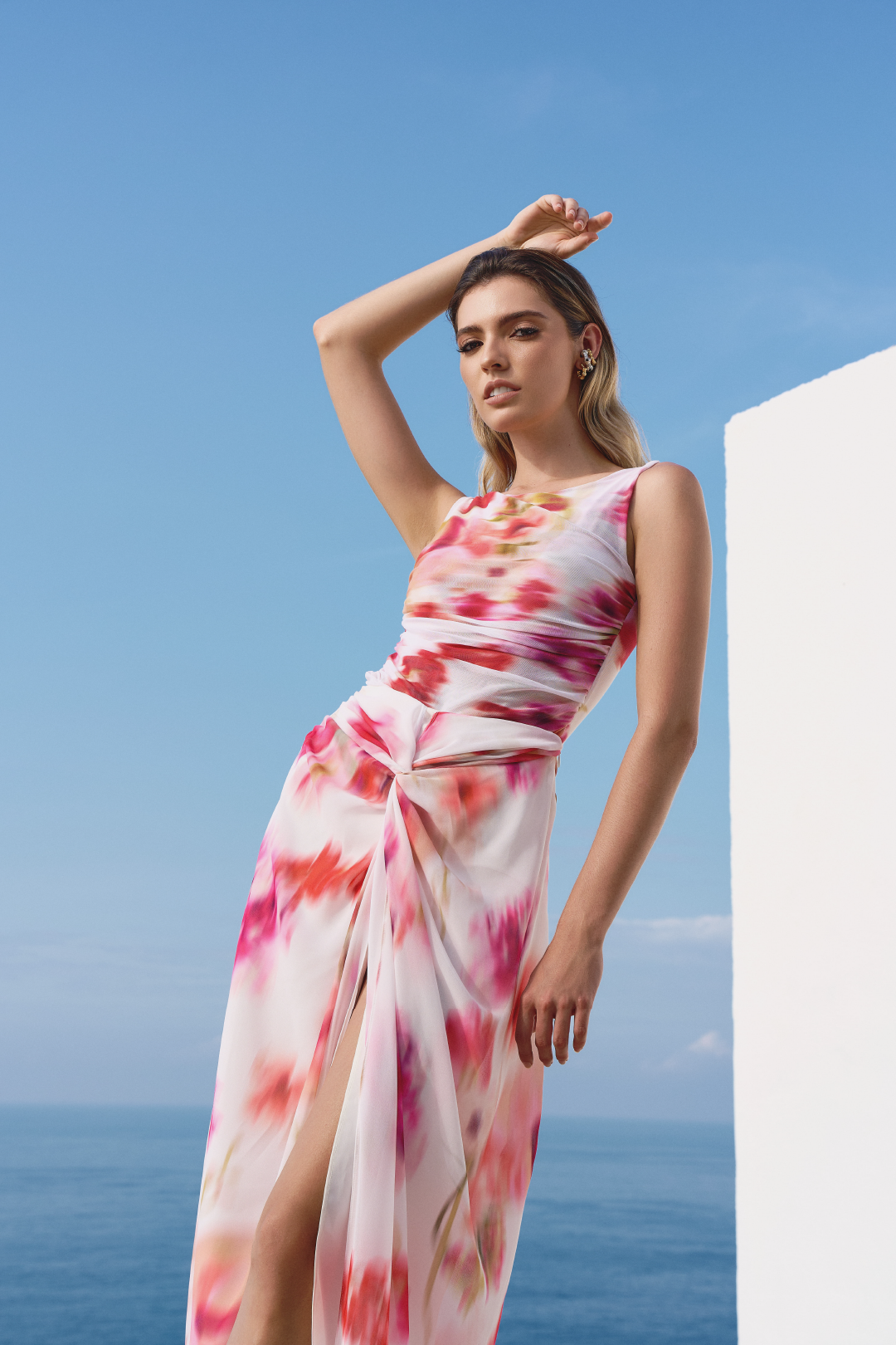 A model wearing a pink and red blurred flowers printed cream skirt with a split in the middle by Monica Arguedas.