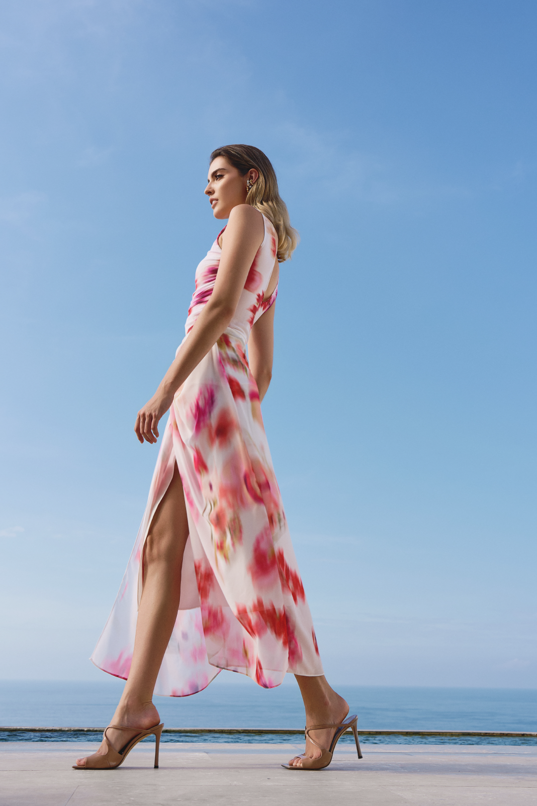 A model wearing a pink and red blurred flowers printed cream skirt with a split in the middle by Monica Arguedas.
