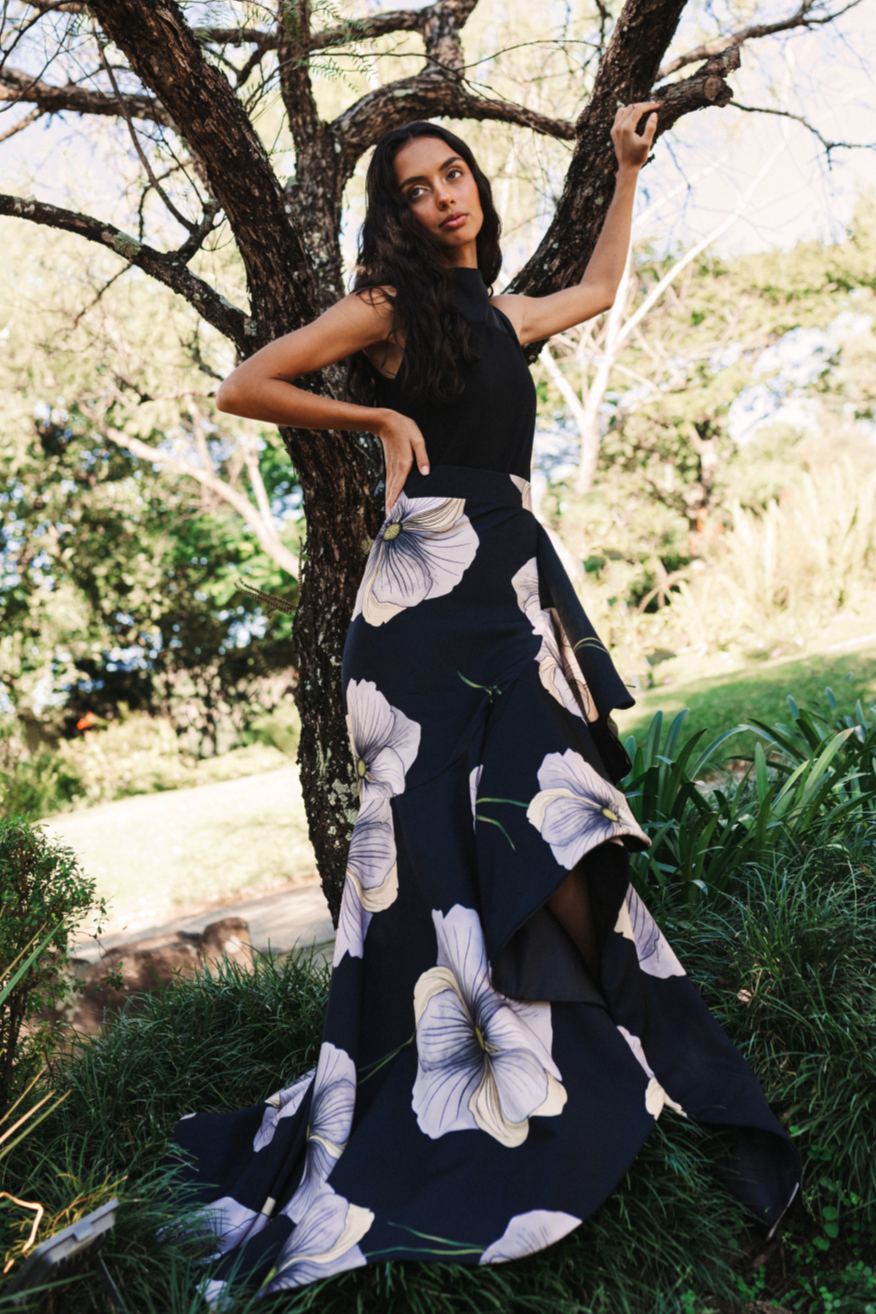 A model wearing a black ruffled skirt with a creme flower print by Monica Arguedas.