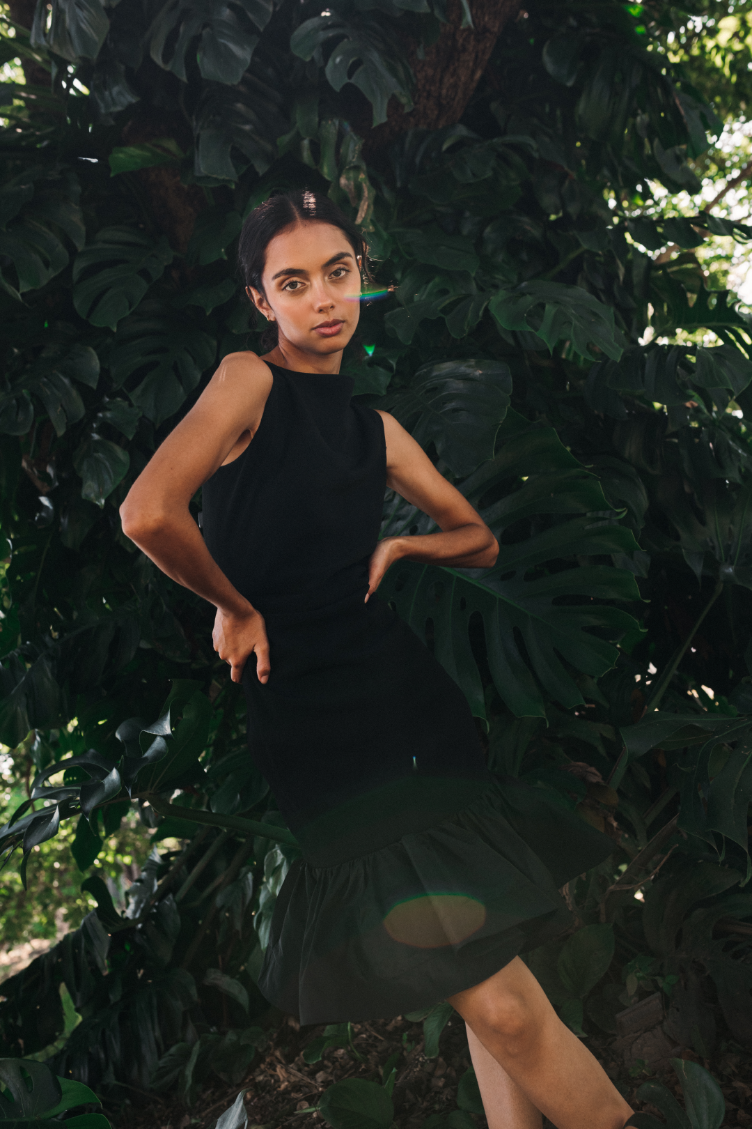 Model wearing a black solid dress with stirs in a salvadoran forest.