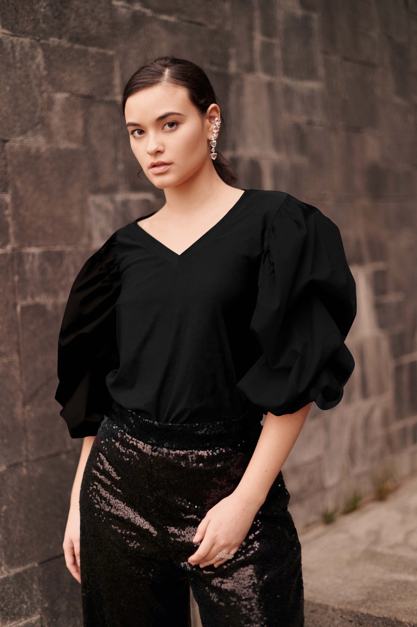 A model wearing a solid black tee with puffy sleeves by Monica Arguedas.