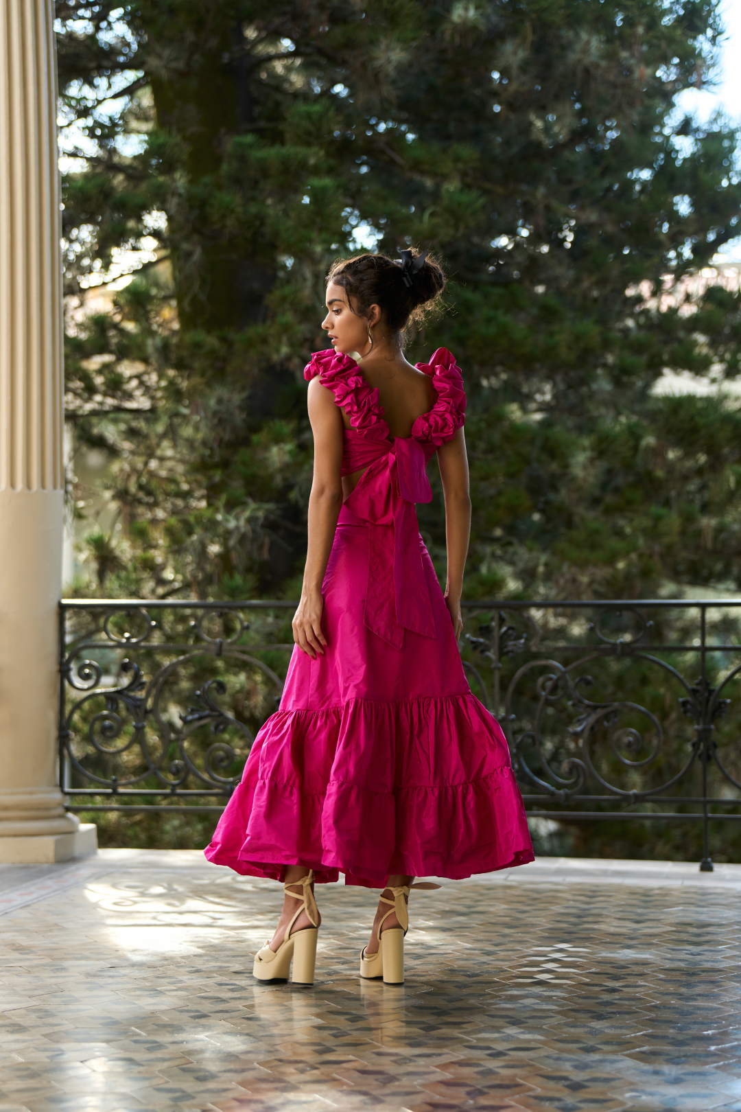 A model wearing a long bright pink skirt with ruffles by Monica Arguedas.