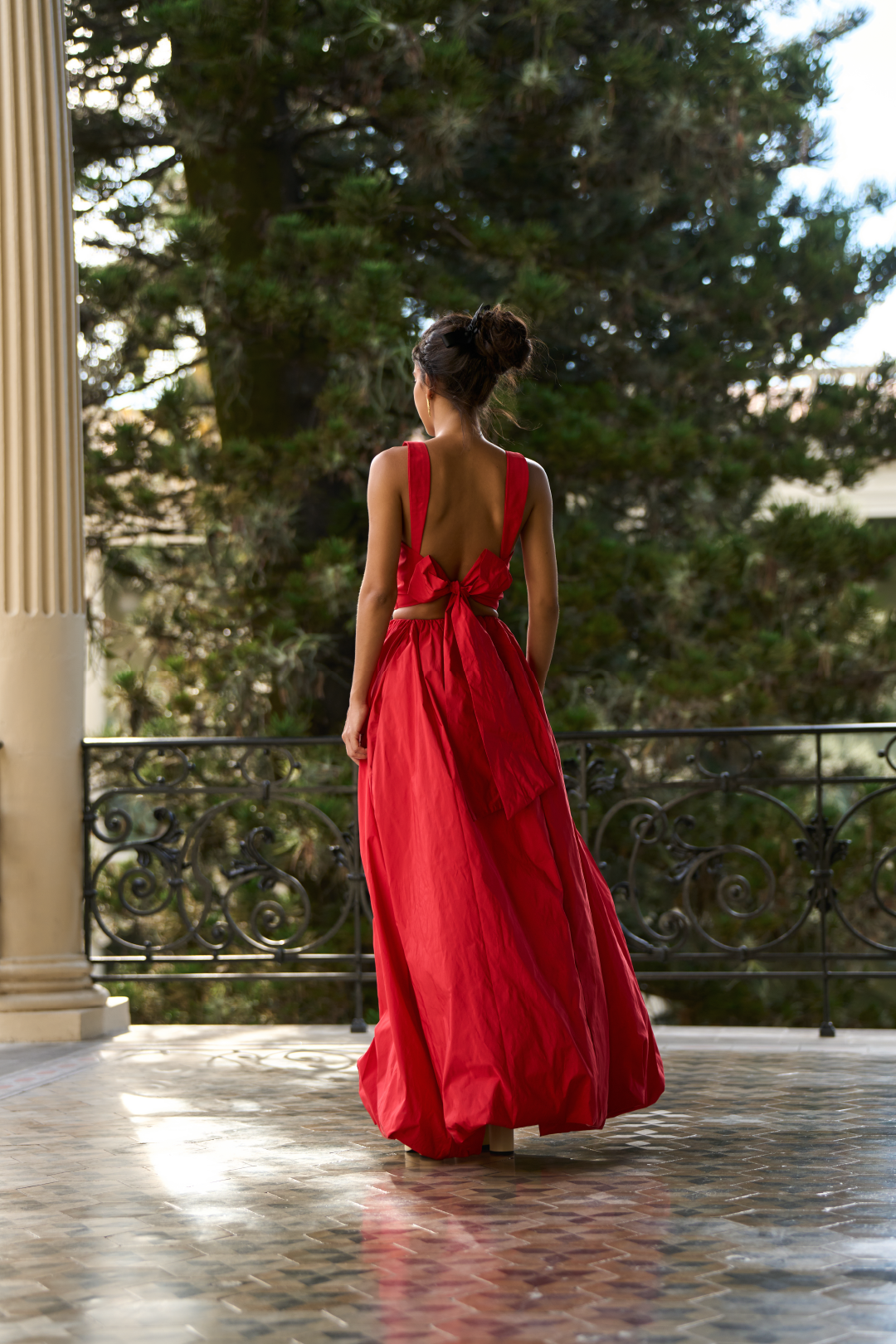 A model wearing a red flowy skirt by Monica Arguedas.