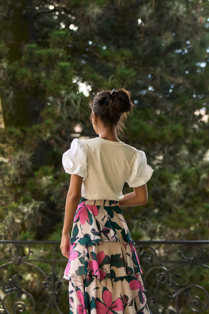 A model wearing a creme top with puffy sleeves by Monica Arguedas.