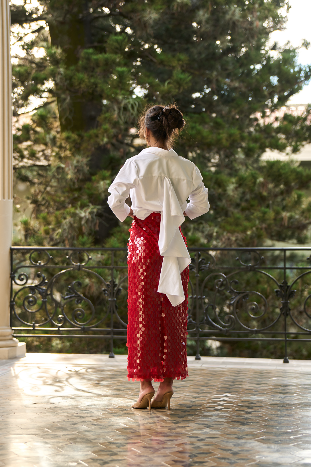 A model wearing a long red sequined skirt by Monica Arguedas.