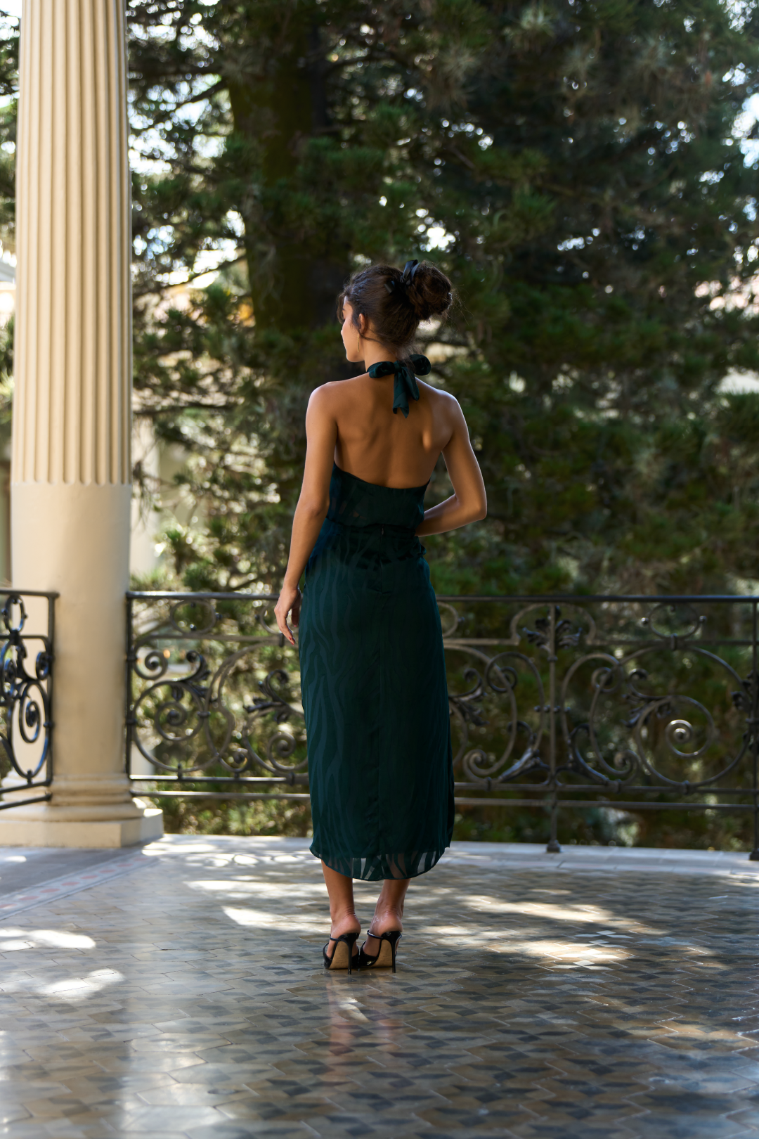 A model wearing a green flowy skirt with a slit by Monica Arguedas.