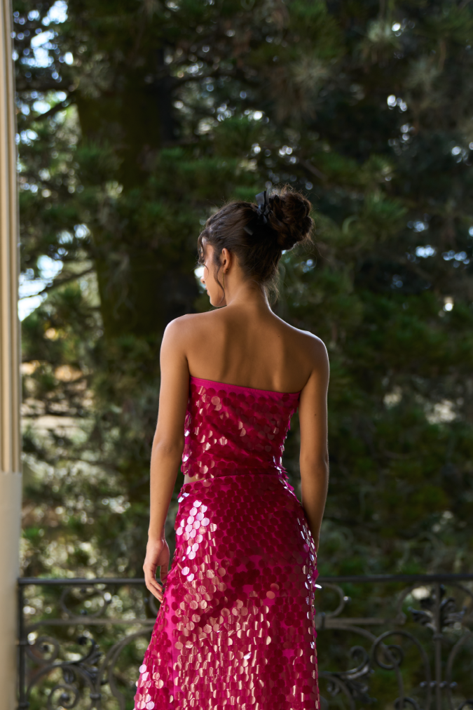A model wearing a bright pink sequined tube top by Monia Arguedas
