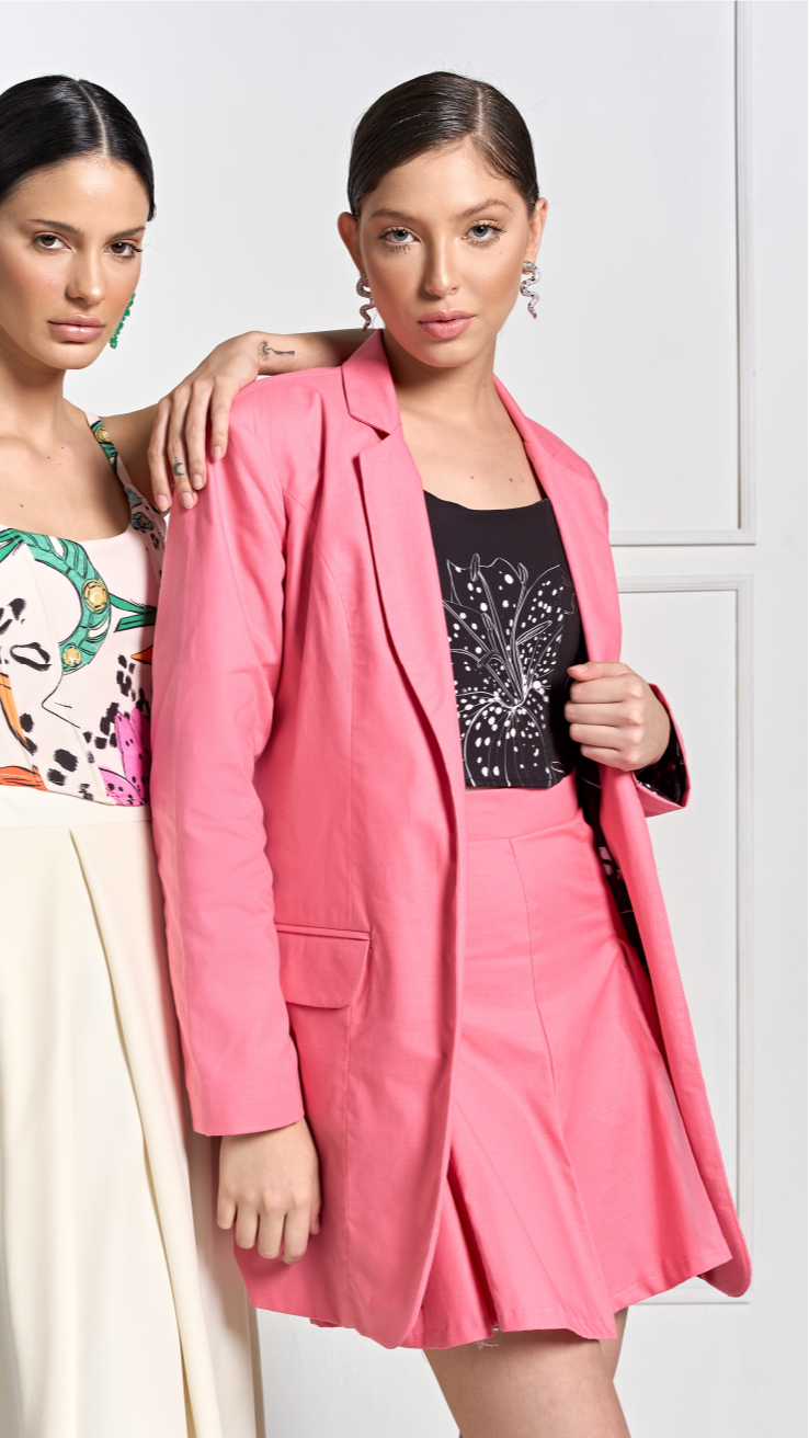 A model wearing a bright pink pleated skirt by Monica Arguedas.