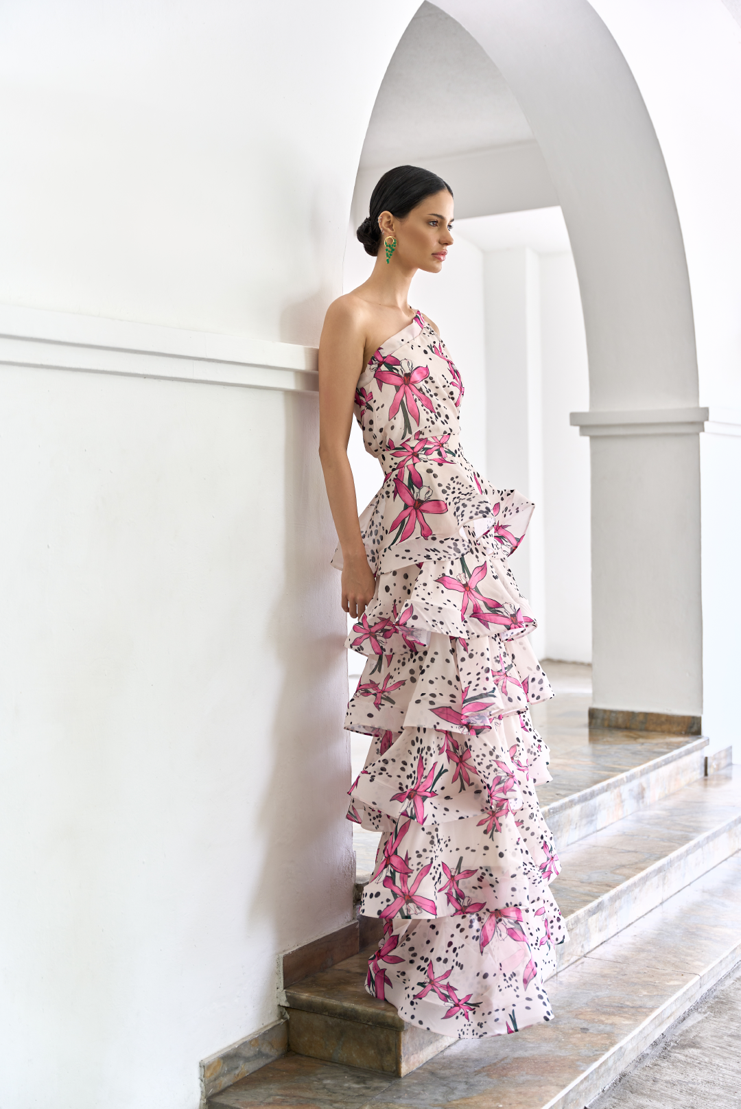 A model wearing a one-shoulder cream top with dotted flower print by Monica Arguedas.