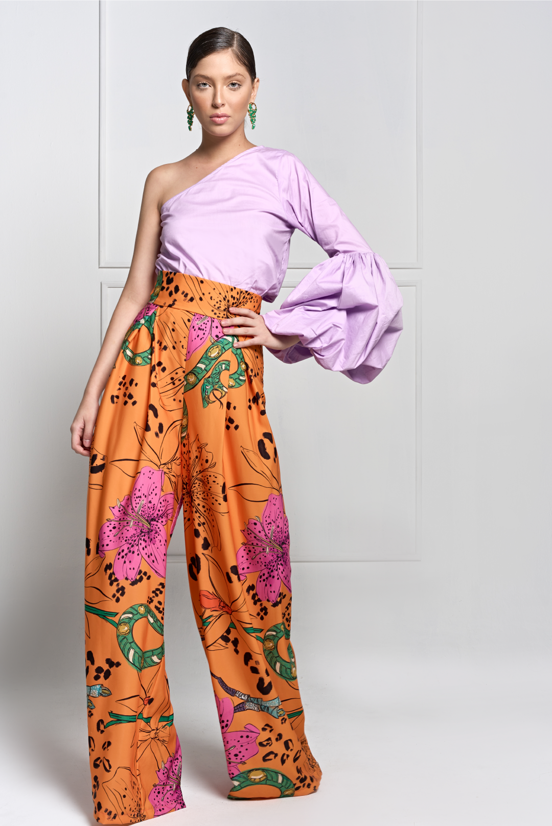 A model wearing a lilac one shoulder top with puffy long sleeve by Monica Aguedas.