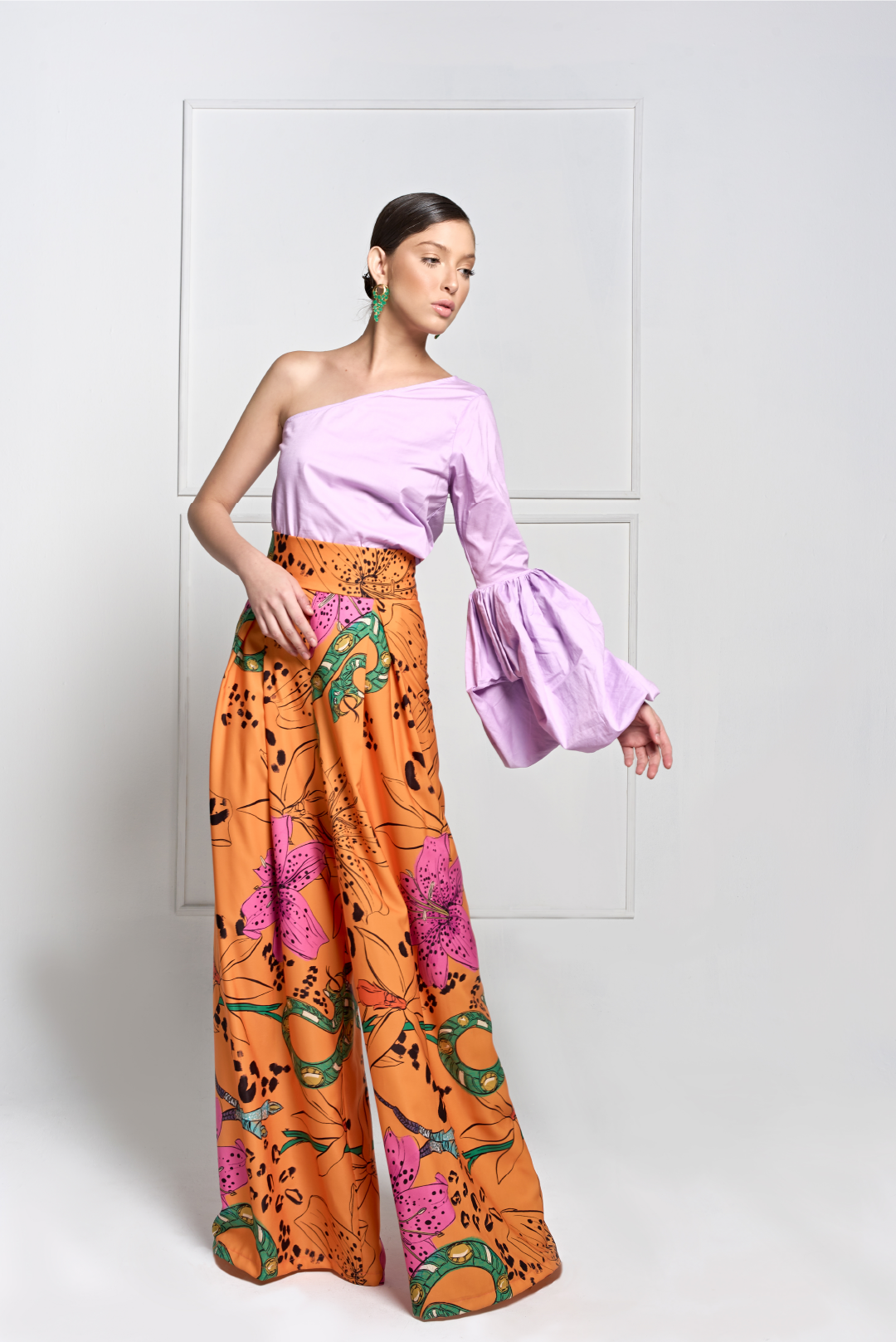 A model wearing a lilac one shoulder top with puffy long sleeve by Monica Aguedas.
