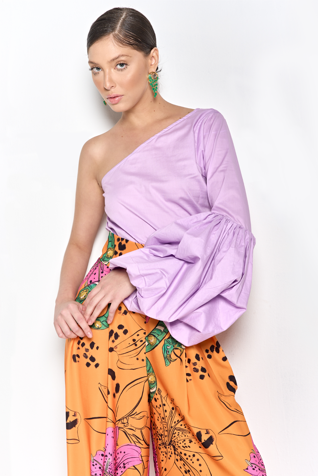 A model wearing a lilac one shoulder top with puffy long sleeve by Monica Aguedas.