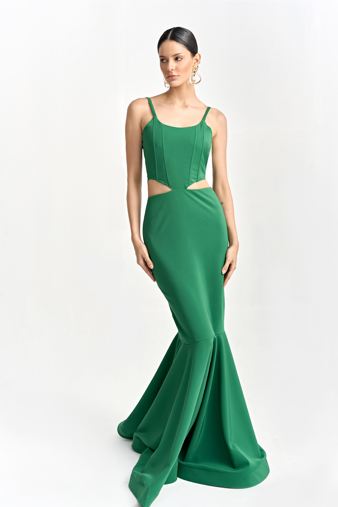 A model wearing a long solid green dress by Monica Arguedas.