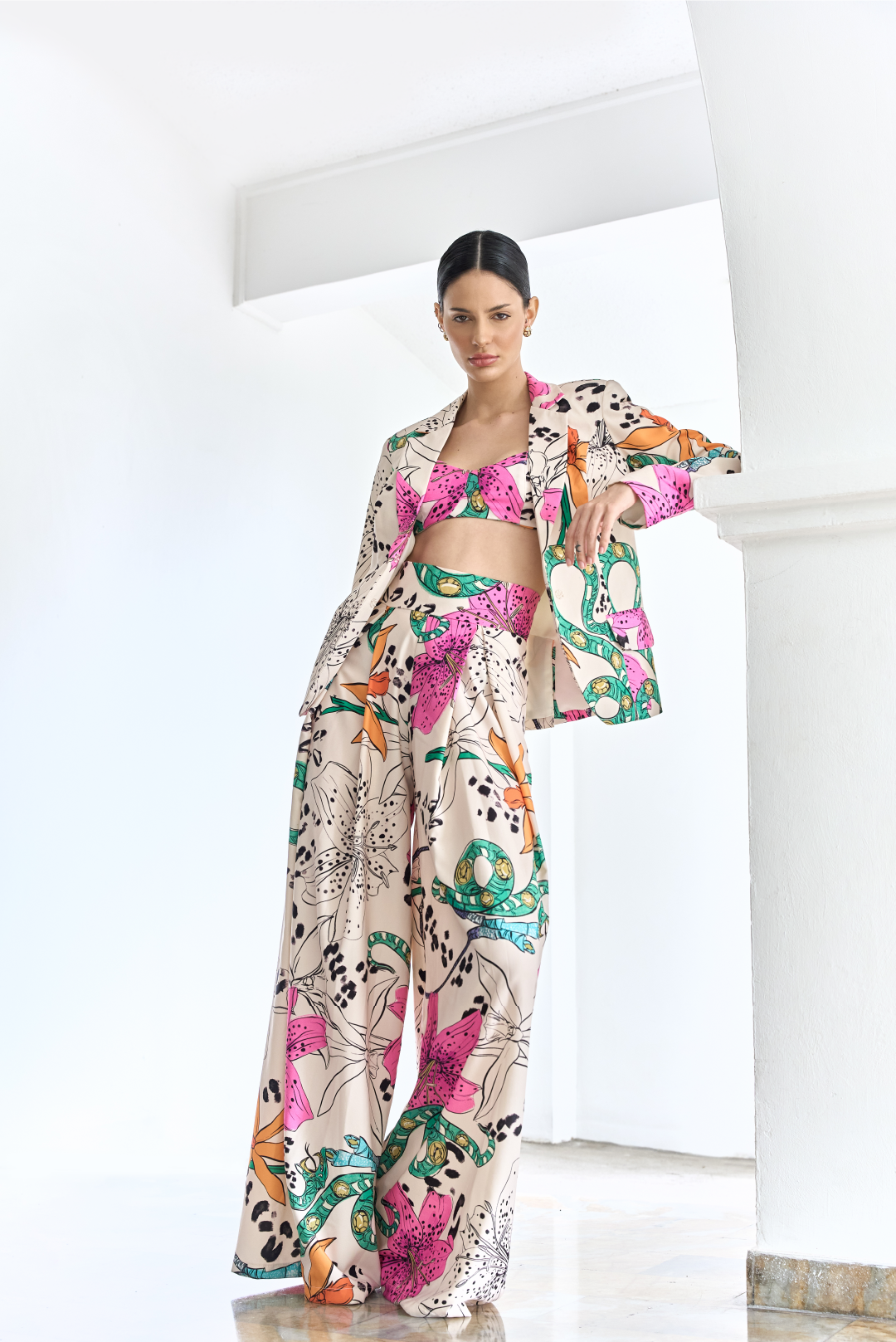Model wearing a creme floral print set of a blazer, bralette and pants by Monica Arguedas.