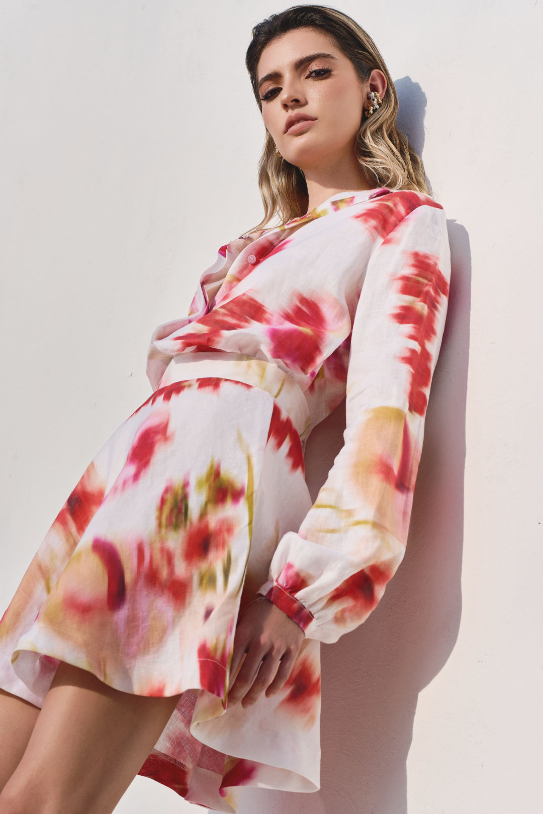 A model wearing a long sleeve top and a mini skirt both with pink floral print by Monica Arguedas.