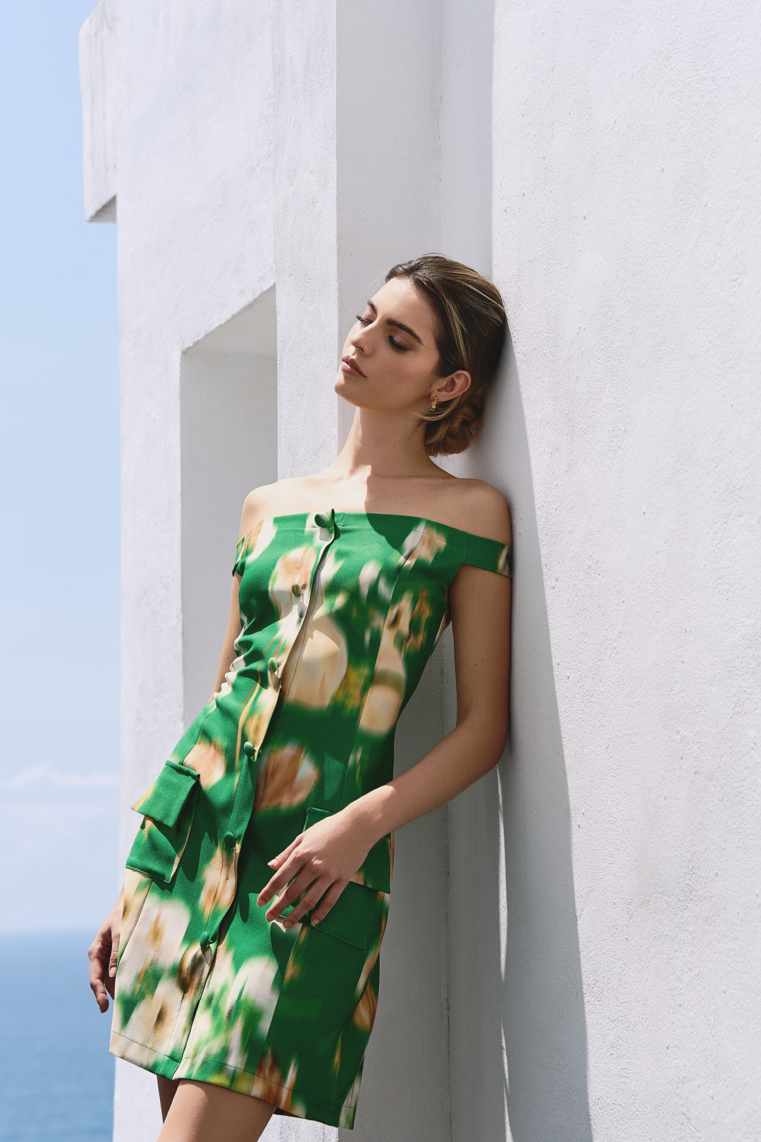 A model wearing a white flower pattern green mini dress by Monica Arguedas.
