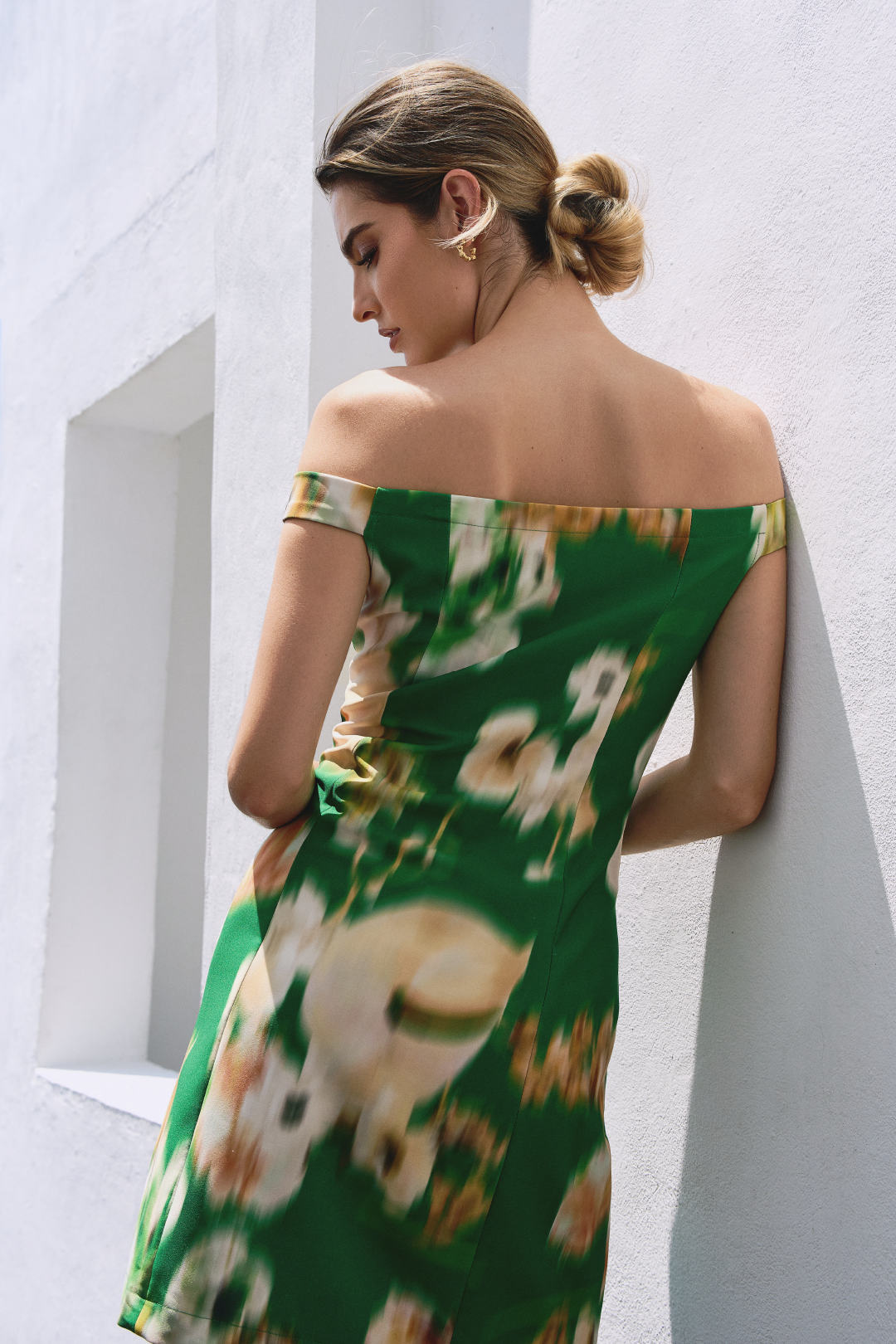A model wearing a white flower pattern green mini dress by Monica Arguedas.