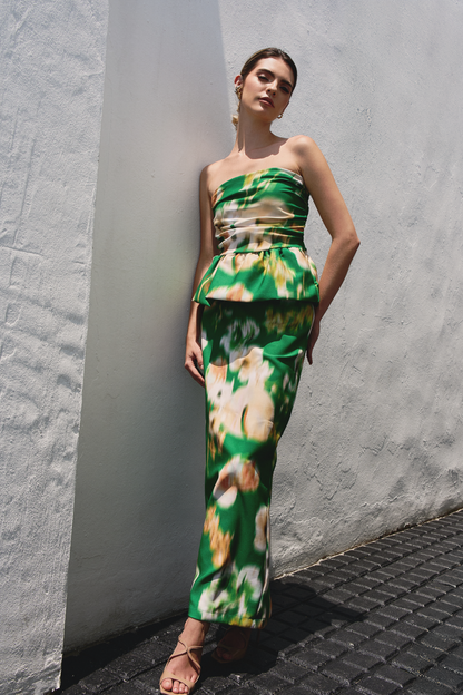 A model wearing a green flowy skirt with blurred floral print by Monica Arguedas