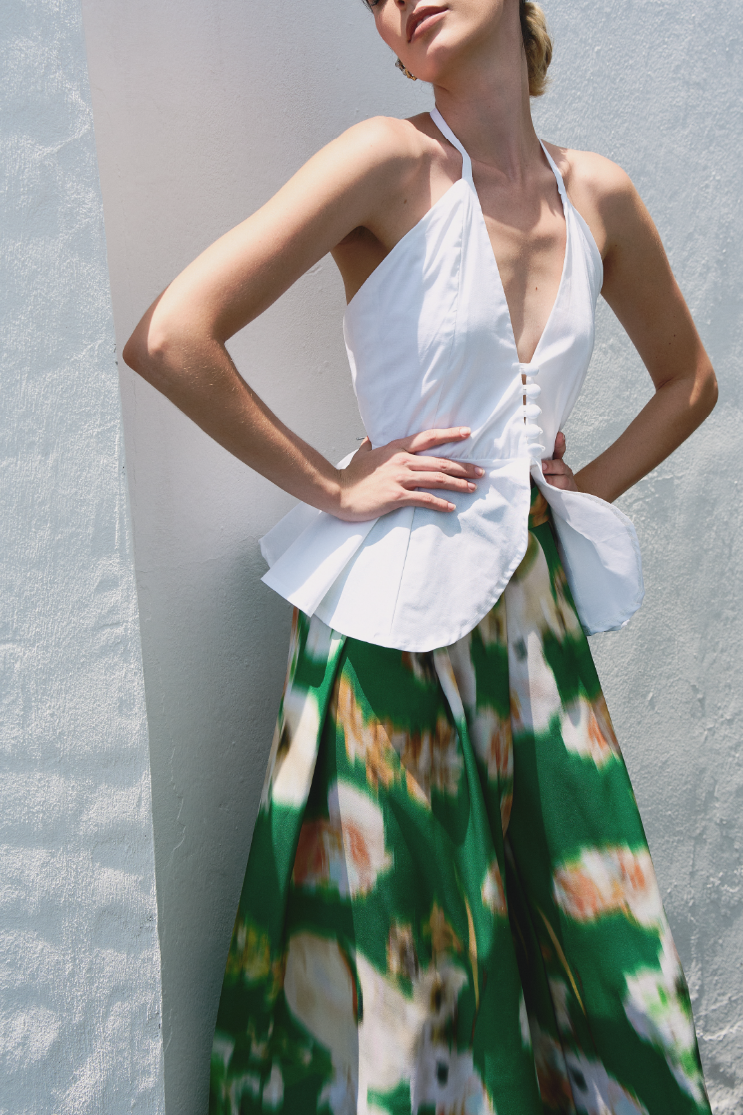 A model wearing green pants with blurred floral print by Monica Arguedas