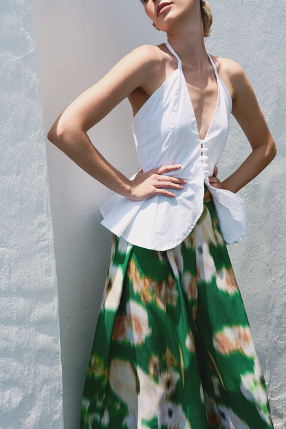 A model wearing green pants with blurred floral print by Monica Arguedas