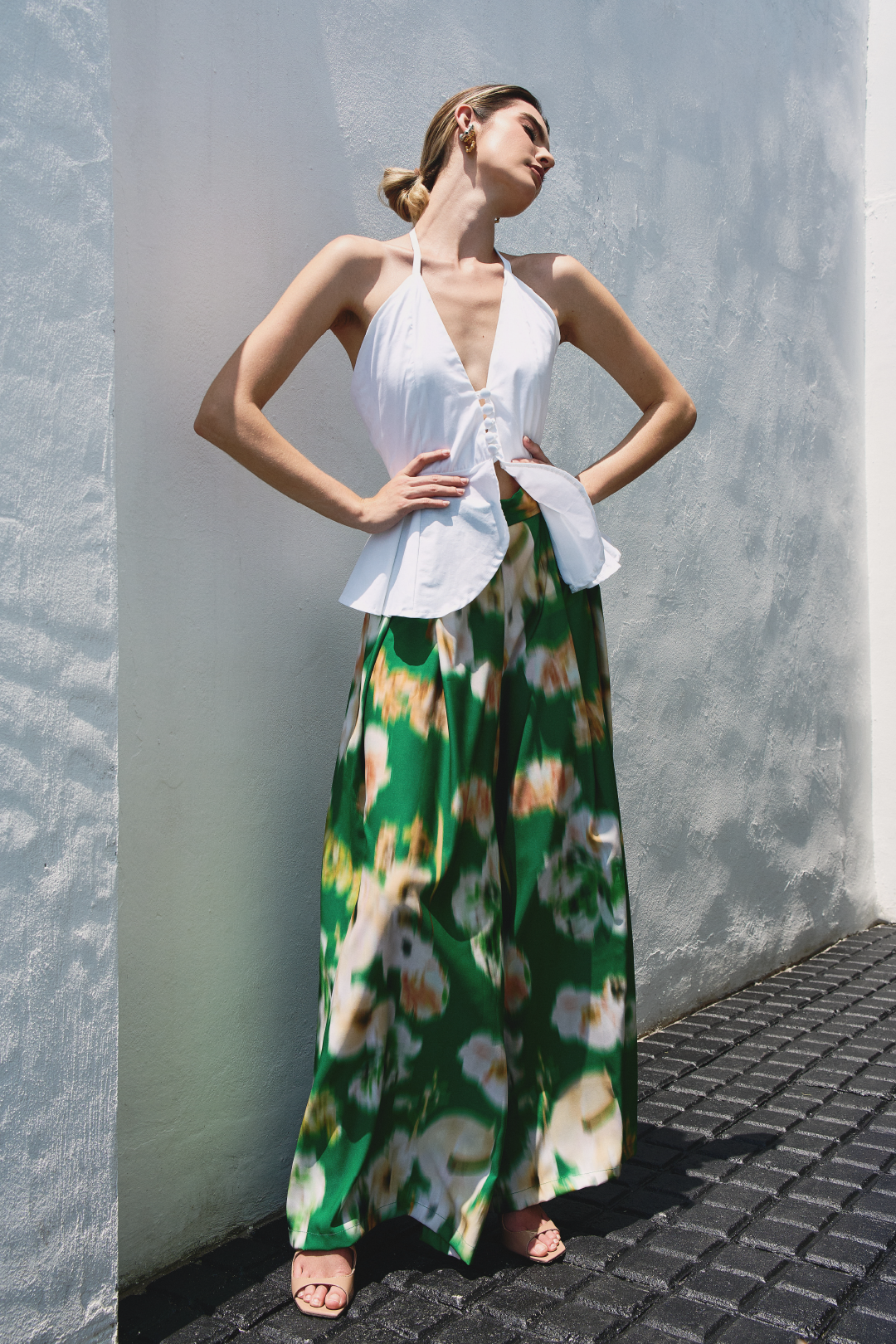 A model wearing green pants with blurred floral print by Monica Arguedas