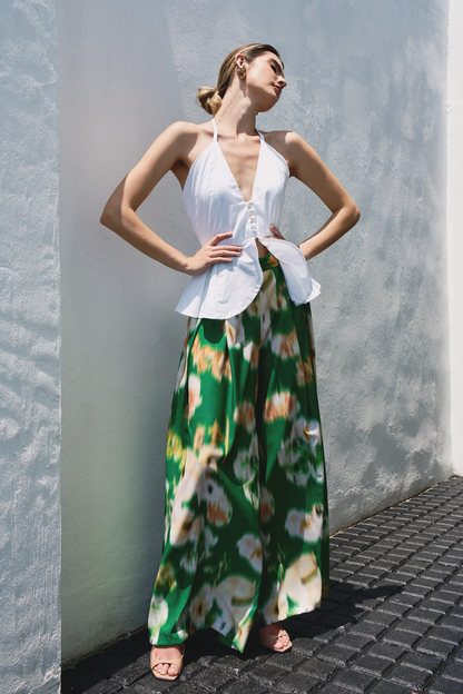 A model wearing green pants with blurred floral print by Monica Arguedas