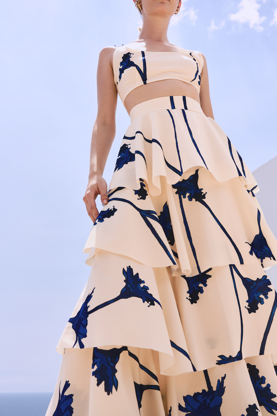 A model wearing a cream ruffled skirt with blue flowers by Monica Arguedas