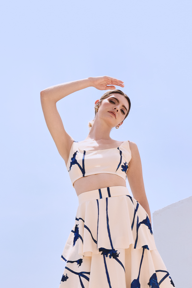 A model wearing a cream top with blue flowers by Monica Arguedas