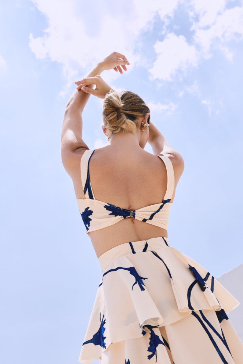 A model wearing a cream top with blue flowers by Monica Arguedas