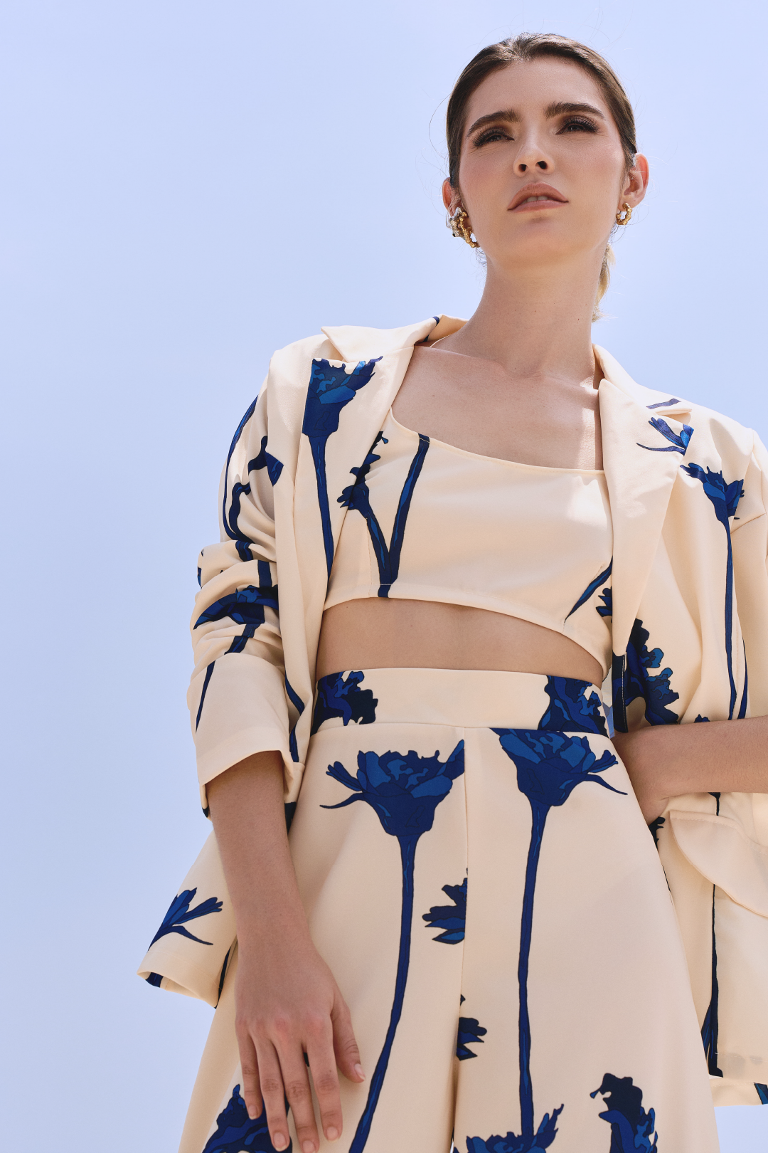 A model wearing a cream top with blue flowers by Monica Arguedas