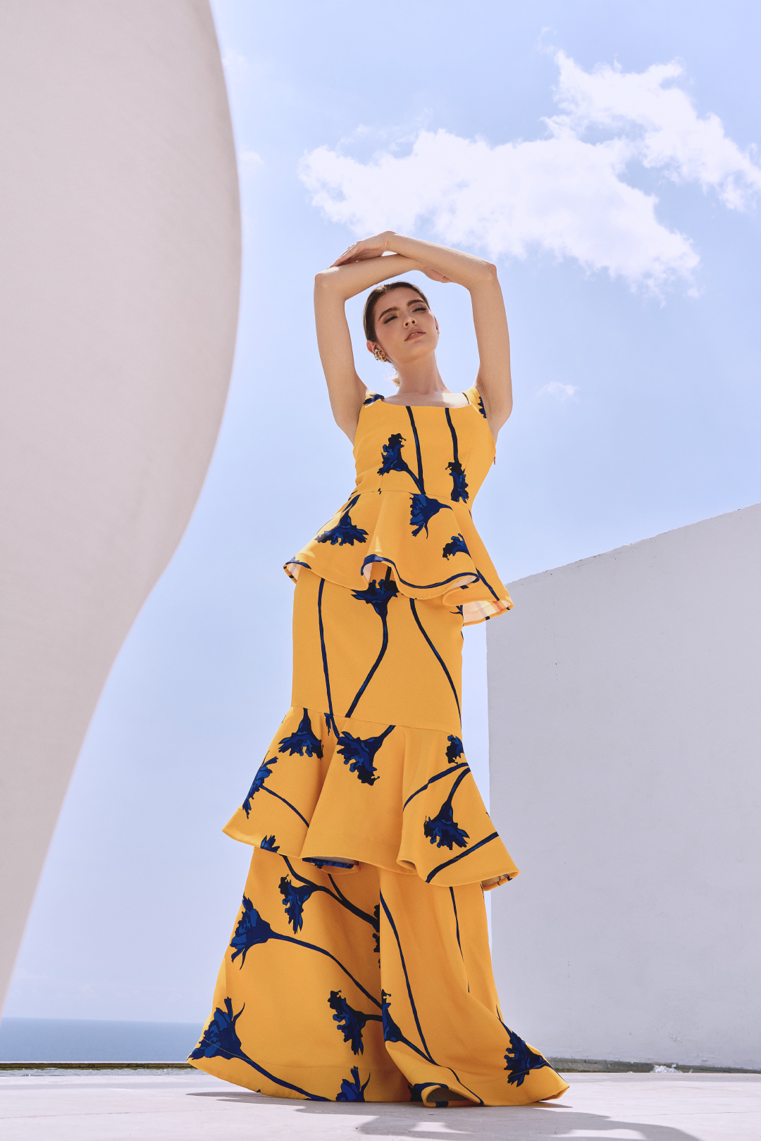 A model wearing a yellow squared-neck top with blue flowers