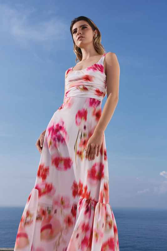 A model wearing a white scrunched dress with a blurred floral print by Monica Arguedas.