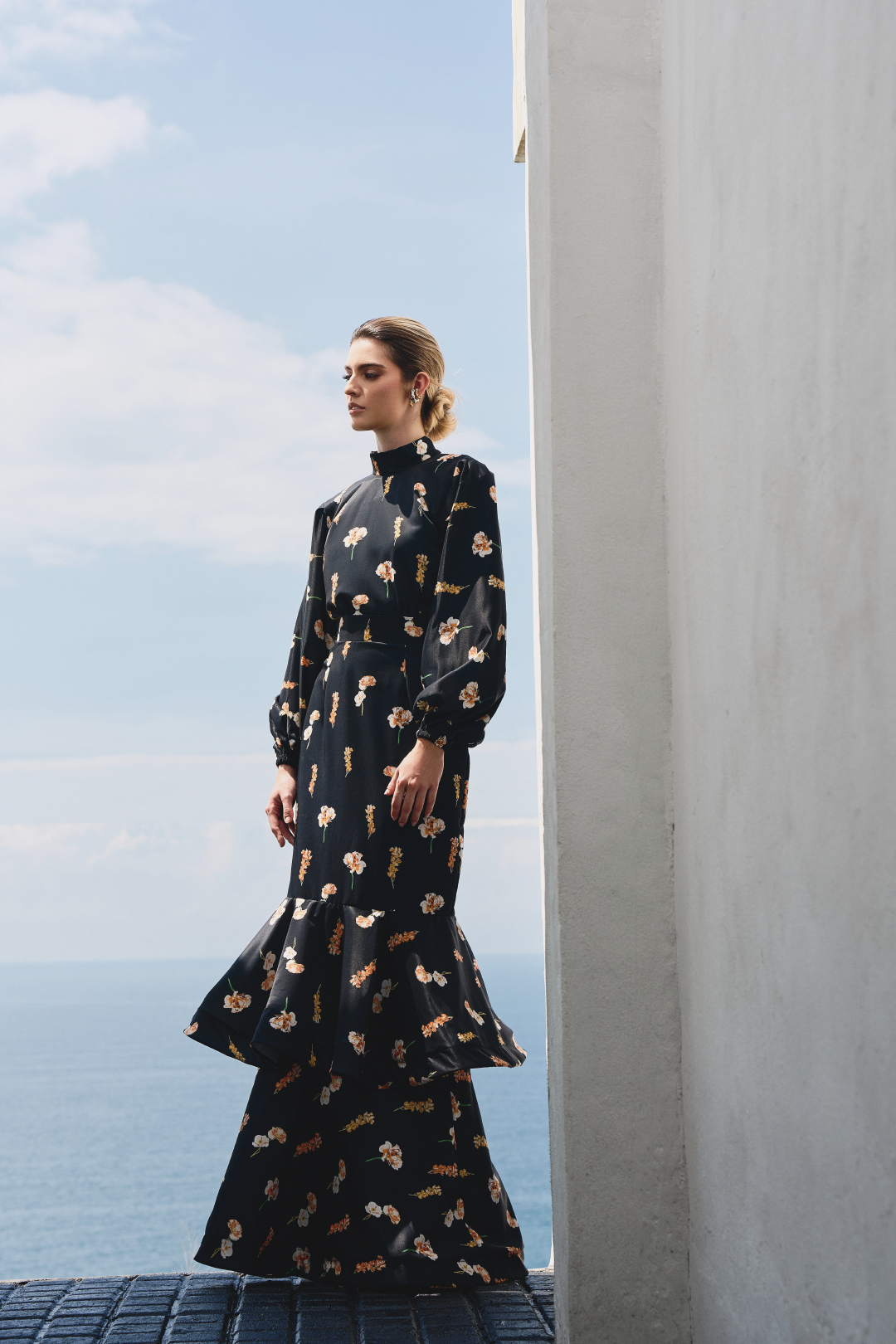 A model wearing a black ruffled skirt with floral print by Monica Arguedas