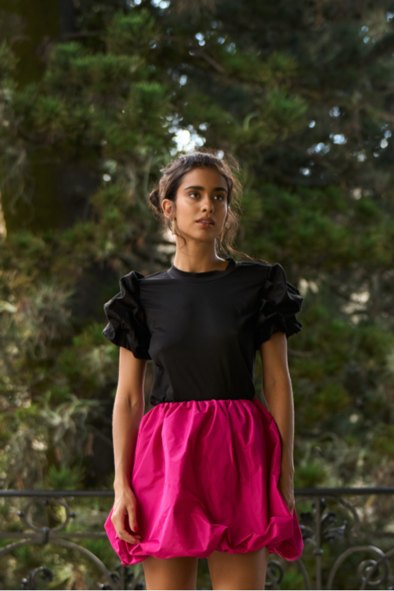 A model wearing a solid black tee with puffy sleeves by Monica Arguedas.