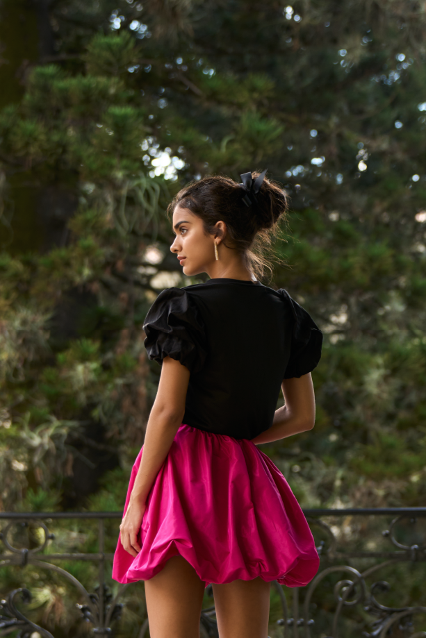 A model wearing a solid black tee with puffy sleeves by Monica Arguedas.