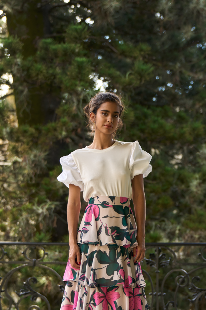 A model wearing a creme top with puffy sleeves by Monica Arguedas.