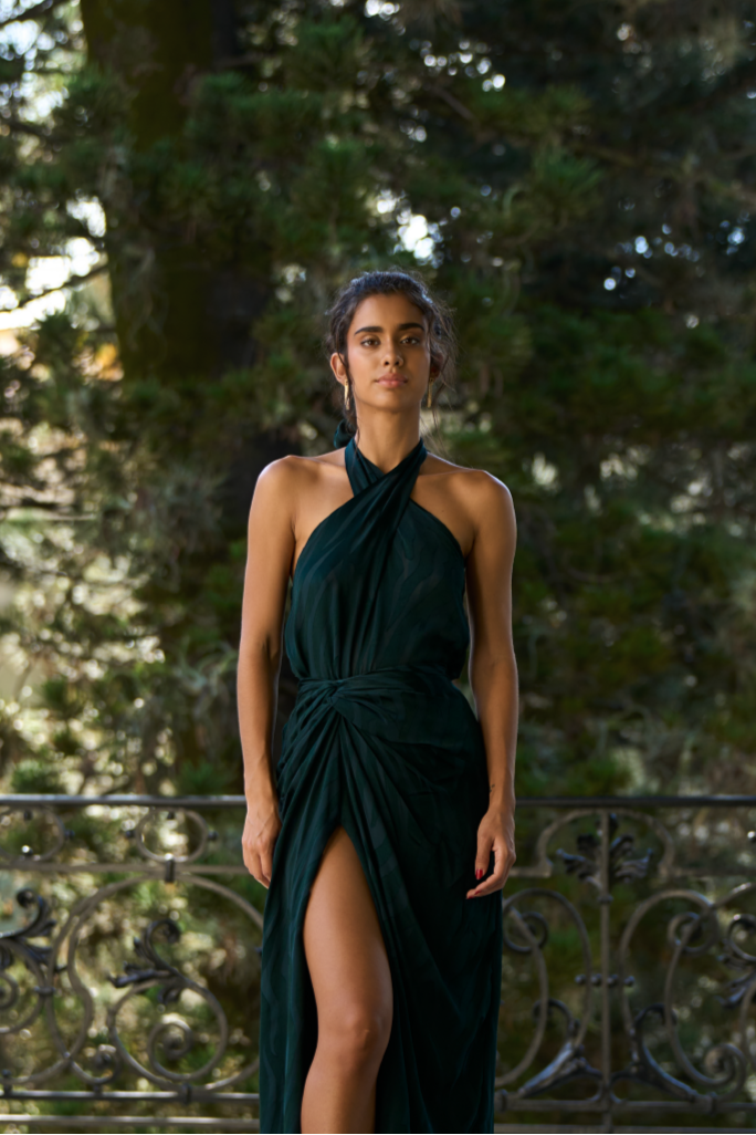 A model wearing a green halter top with an open back by Monica Arguedas.