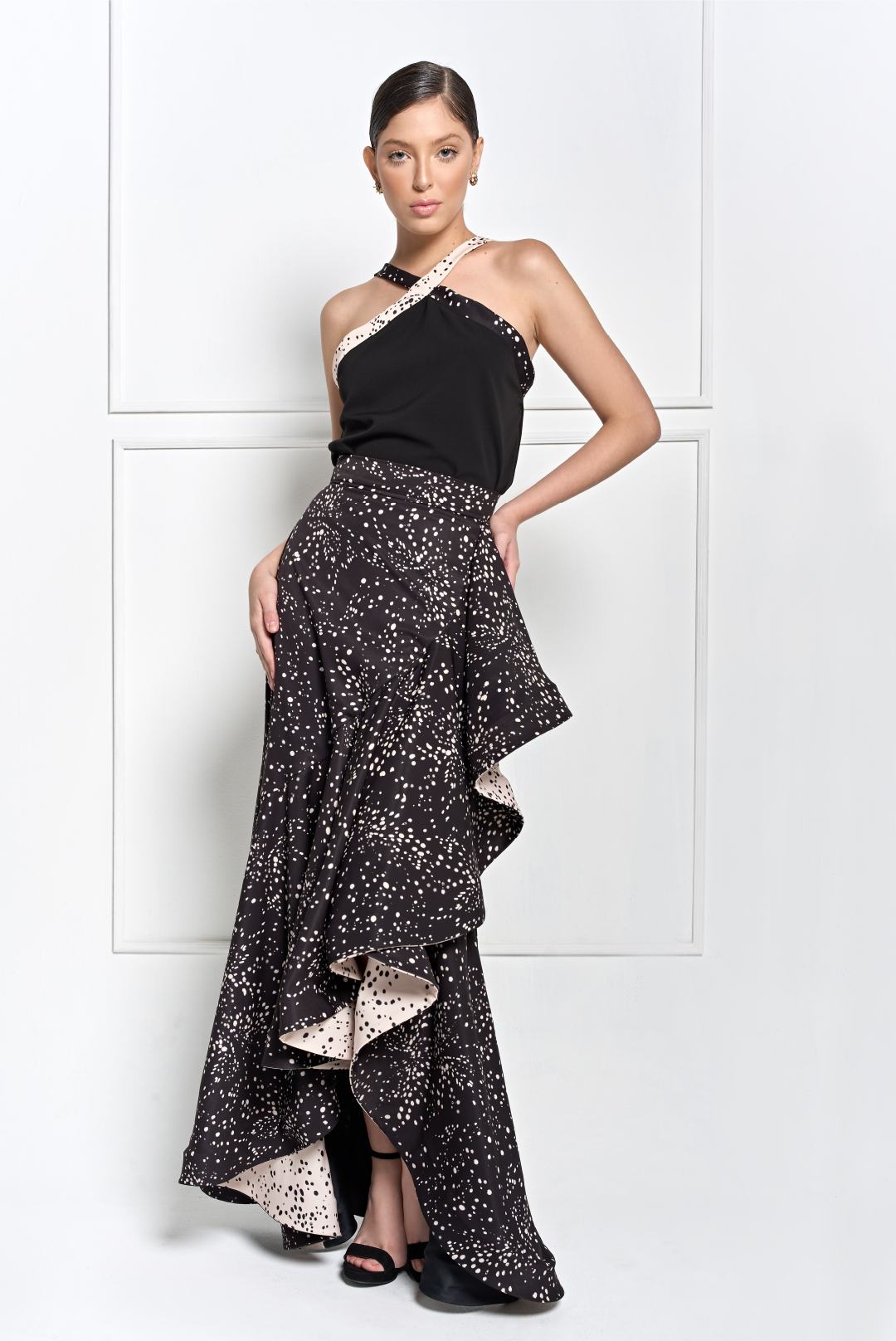 A model wearing a black top with creme and black dotted cross-straps by Monica Arguedas.